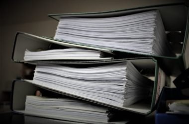 Close-up of stacked binders filled with documents for office or educational use.